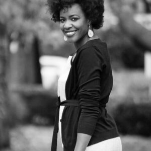 Portrait of pretty Caucasian therapist in elegant dress and smiling while standing at modern office.